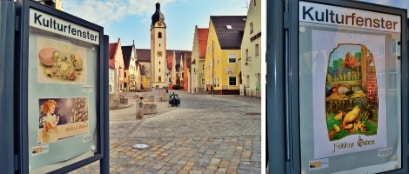 4 archivierte Ostergrußkarten zu sehen in den Kulturschaukasten in Schwandorf. Im Hintegrund der Schwandorfer Marktplatz.