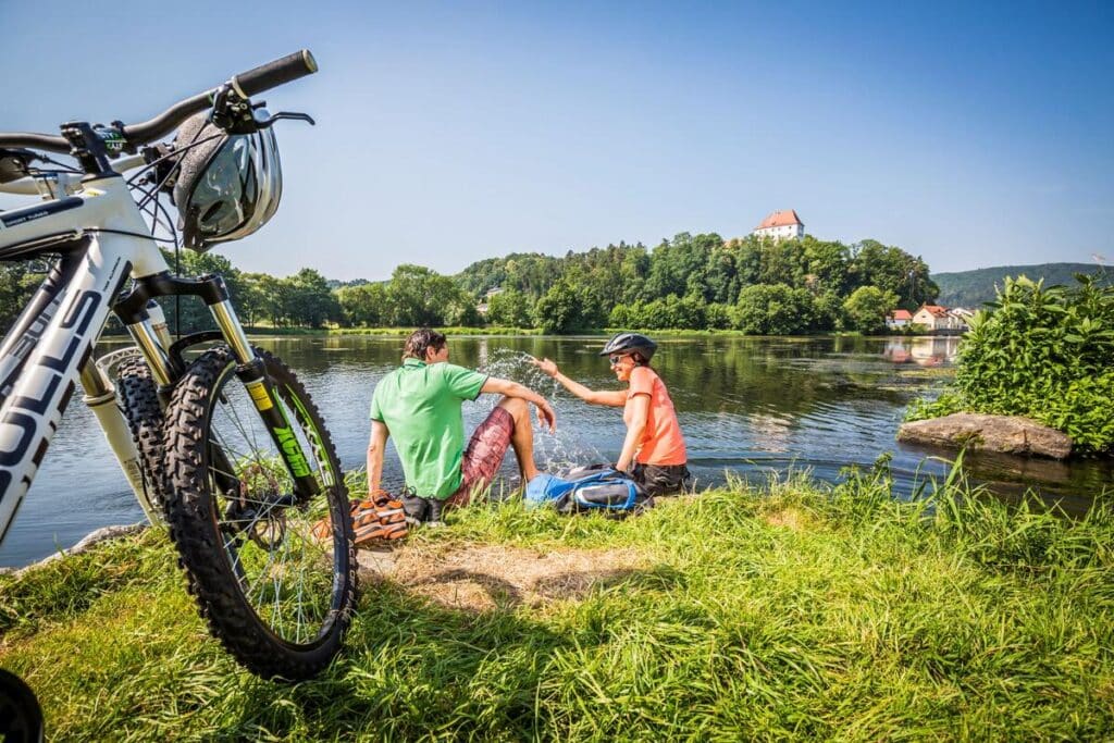Zwei Radfahrer legen eine Pause am Fluss Regen ein.